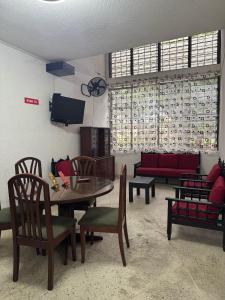 a living room with a table and chairs and a tv at Hostel Flandes tu sitio in Flandes