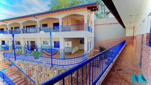an apartment building with blue railings and a balcony at Nova Aliança Suítes por Temporada em Amparo NÃO SOMOS POUSADA in Amparo