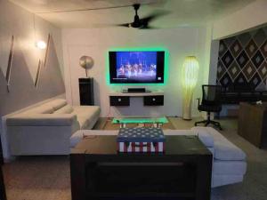 Una sala de estar con un sofá y un televisor. en La marquesina guess home, en Loiza