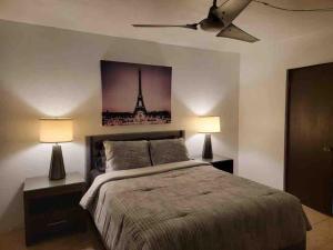 1 dormitorio con 1 cama con 2 lámparas y la torre eiffel en La marquesina guess home, en Loiza 2 fotos más