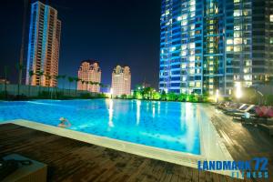 a large swimming pool in a city at night at Calidas Landmark 72 Royal Residence Hanoi in Hanoi