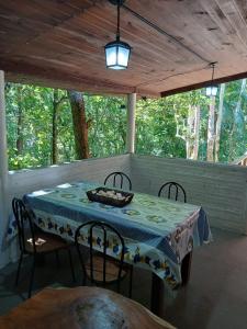 a table and chairs on a screened in porch at Canto da Cachoeira relaxe ao som das águas in Tijucas