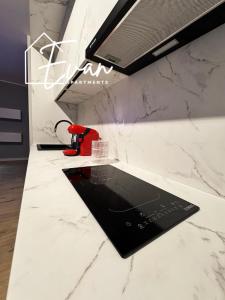 a kitchen with white marble countertops and a red appliance at Luxury Park View Apartment by Evan Apartments in Şelimbăr +15 photos