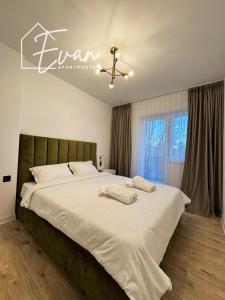 a bedroom with a large white bed with a ceiling at Luxury Park View Apartment by Evan Apartments in Şelimbăr