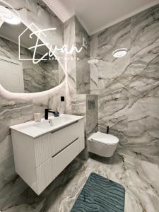 a bathroom with a white sink and a toilet at Luxury Park View Apartment by Evan Apartments in Şelimbăr