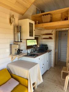 a kitchen with a table and a sink in a room at Tiny House chez Annette in Darvoy