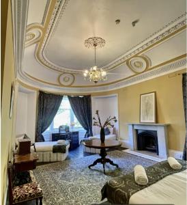 ゴアブリッジにあるHarvieston Estate Roomsのシャンデリアと暖炉付きの広いリビングルーム