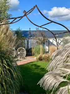 a garden with two wicker chairs and grass at Villa Botanica in Odargowo