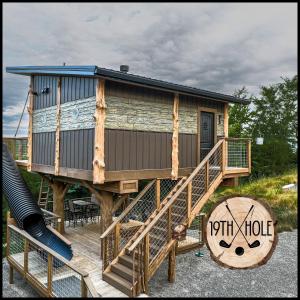 a tree house with a slide on a deck at "The 19th Hole" Luxury Treehouse w Golf Views & Private 20ft Slide - 10 Miles from Dollywood in Catlettsburg