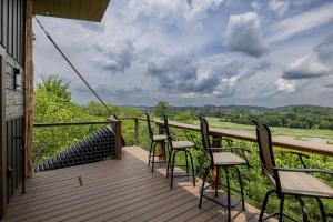 a deck with chairs and a view of the countryside at "The 19th Hole" Luxury Treehouse w Golf Views & Private 20ft Slide - 10 Miles from Dollywood in Catlettsburg +12 photos