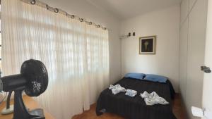 a bedroom with a bed and a window with a fan at Nova Aliança Suítes por Temporada em Amparo NÃO SOMOS POUSADA in Amparo +33 photos