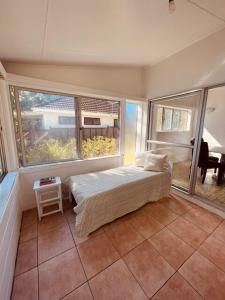 een slaapkamer met een bed en een groot raam bij Maree's Beachfront House - Free Internet in Arorangi