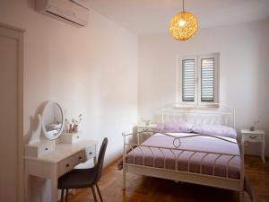 ein Schlafzimmer mit einem Bett, einem Schreibtisch und einem Spiegel in der Unterkunft Meerblick Apartment mit großer Sonnenterrasse für 6 Personen in Sumartin