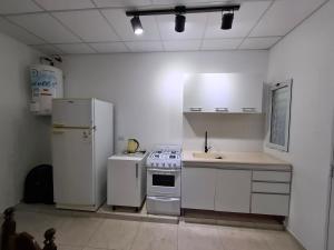 a kitchen with white appliances and a sink at Nuevo Departamento Moderno Charata in Charata