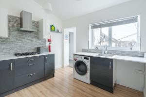 a kitchen with a washing machine and a sink at Fife coastal corner in Buckhaven