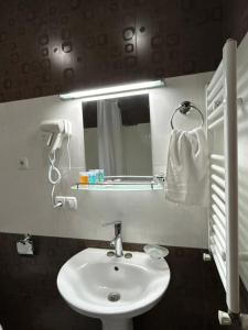 een badkamer met een witte wastafel en een spiegel bij Hotel Wintera Gudauri in Goedaoeri +50 foto's