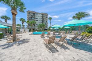 a group of chairs and umbrellas next to a pool at Our House at the Beach W-704 in Siesta Key