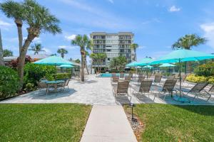 a patio with tables and chairs with umbrellas at Our House at the Beach W-704 in Siesta Key