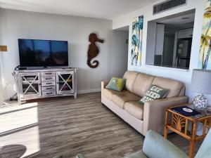 a living room with a couch and a flat screen tv at Our House at the Beach W-704 in Siesta Key