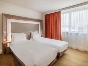 Giường trong phòng chung tại Novotel Lyon Centre-Confluence Bord de Saone