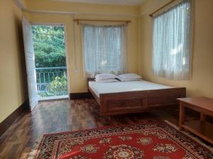 ein Schlafzimmer mit einem Bett und einem großen Fenster in der Unterkunft Mala cottage in Kalimpong