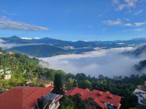Blick auf eine Stadt mit Wolken in den Bergen in der Unterkunft Mala cottage in Kalimpong + 1 Foto