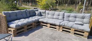 Eine Couch mit blauen Kissen steht auf einer Terrasse. in der Unterkunft chambre plan d eau in Saint-Biez-en-Belin