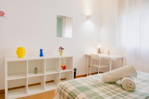 Un dormitorio blanco con una cama y un escritorio. en Quartos da Expo, en Lisboa