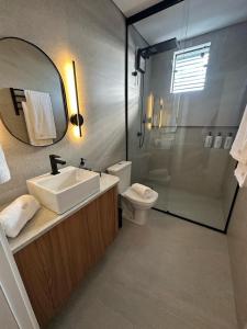 a bathroom with a sink and a toilet and a mirror at Apartamento Novo - Conforto no Saguaçú! in Boa Vista