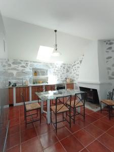 a kitchen with a table and chairs and a fireplace at Casa do Velho Vinhateiro in Gagos