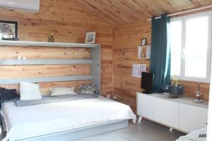 a bedroom with a bed and a wooden wall at Le chalet bien-être de Vanessa in Peyret-Saint-André