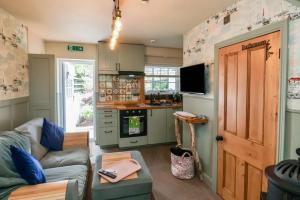 a living room with a couch and a kitchen at Seaglass Cottage in Flamborough