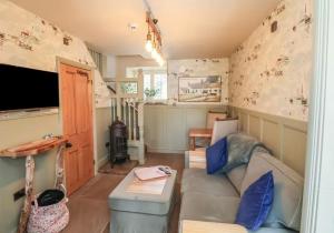 a living room with a couch and a television at Seaglass Cottage in Flamborough