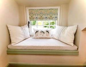 a window seat with three penguins on it in a room at Seaglass Cottage in Flamborough