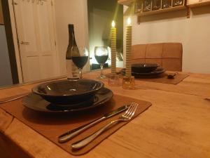 una mesa con dos copas de vino, un plato y un tenedor en Luxe gastenverblijf met wellness in het hart van Friesland, en Akkrum
