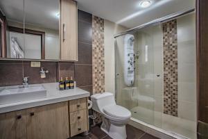 un bagno con wc, doccia e lavandino di Emerald Retreat con Jacuzzi y BBQ a Cuenca Altre 20 foto