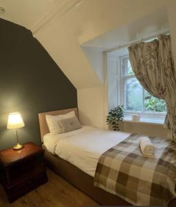 a bedroom with a bed and a window at Harvieston Estate Rooms in Gorebridge