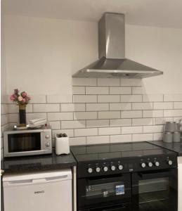 a kitchen with a stove top oven and a microwave at Harvieston Estate Rooms in Gorebridge +66 photos