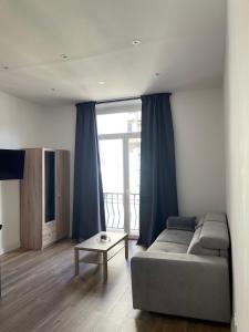a living room with a couch and a large window at Jolie studio in Nice