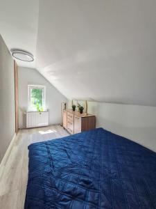 a bedroom with a blue bed and a dresser at Przystanek Karpacz - Apartament Rejkiawik in Karpacz