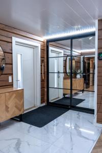 RovaniemiにあるCaptains Riverside Villa, Jacuzzi, BBQ Hutのガラスのドアと木の壁がある更衣室