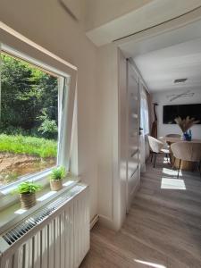 a hallway with a large window and a table at Przystanek Karpacz - Apartament Rejkiawik in Karpacz