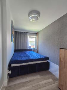 a bedroom with a bed with a blue comforter at Przystanek Karpacz - Apartament Rejkiawik in Karpacz +4 photos