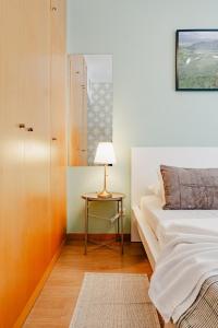 Un dormitorio con una cama y una mesa con una lámpara. en Quartos da Expo, en Lisboa