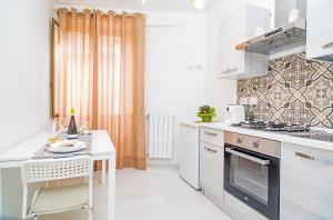 a kitchen with white counters and a stove top oven at L'Antico Cortile di Alba in Viagrande