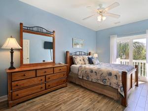 a bedroom with a bed and a dresser and a mirror at South Beach Retreat in Tybee Island +28 photos