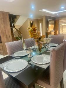 a dining room table with white plates and chairs at House in Miraflores Cuenca in Cuenca