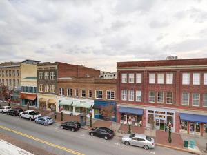 a city street with cars parked in front of buildings at Above Broughton St 3002 in Savannah