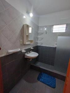 a bathroom with a sink and a mirror at CASA AGUAS AZULES 6 pax LAS GRUTAS in Las Grutas +15 photos