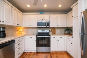 a kitchen with white cabinets and a stove and microwave at Grand View in Edisto Island